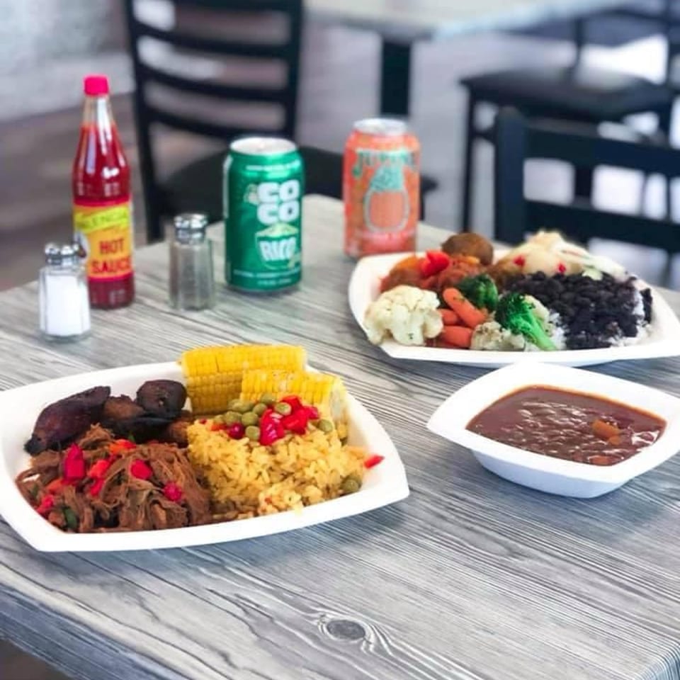 Two Cuban plates with shredded beef, rice, plantains, vegetables, and a side of beans.