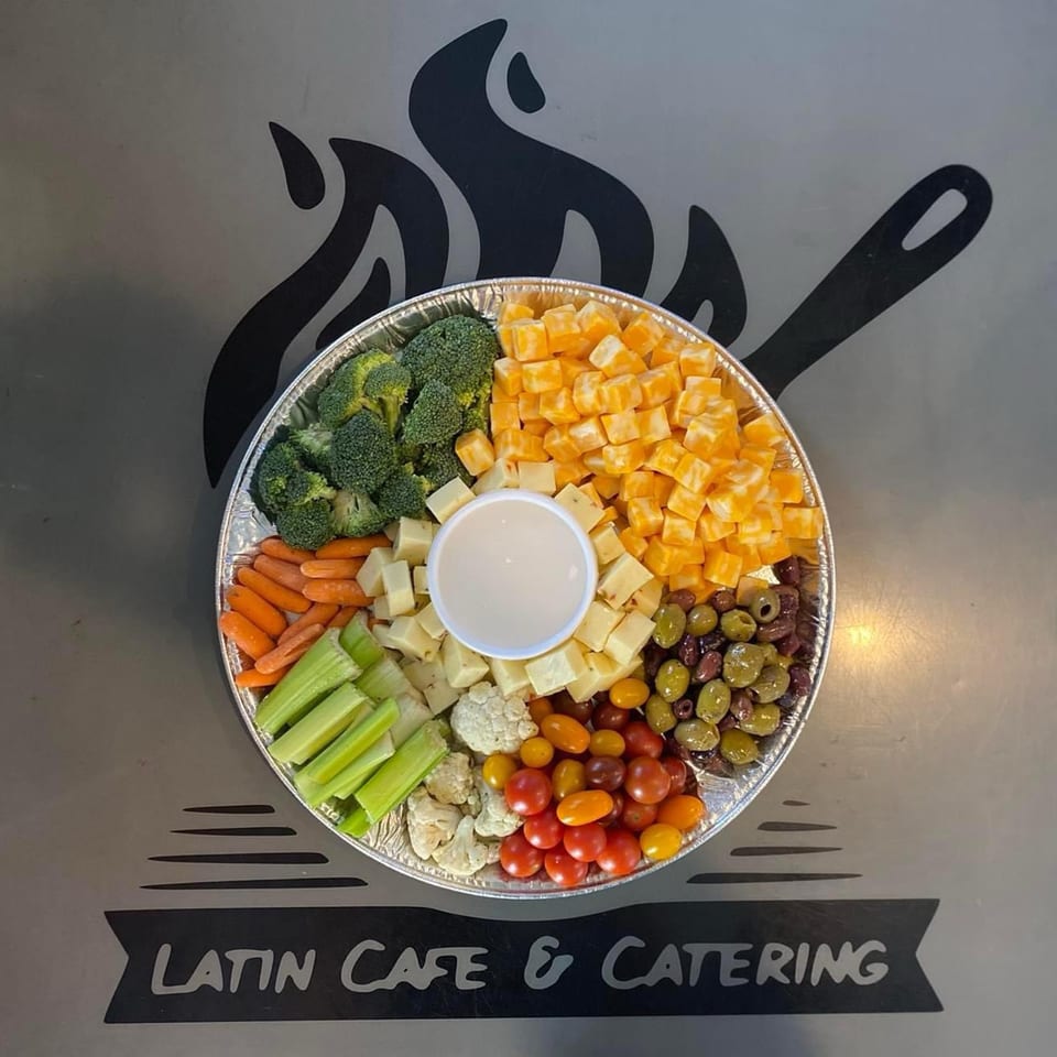 A catering platter with broccoli, carrots, celery, cauliflower, tomatoes, olives, and cheese cubes.